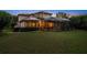 Spacious backyard with pool and house view at dusk at 667 Richmond Close, Tarpon Springs, FL 34688