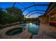 Inviting screened pool and spa with patio and outdoor seating at 667 Richmond Close, Tarpon Springs, FL 34688