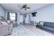 Living room with gray sectional, L-shaped sofa, and wood-look floors at 9252 81St Ave, Seminole, FL 33777