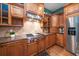 Modern kitchen featuring wood cabinets, granite countertops, and stainless steel appliances at 667 Richmond Close, Tarpon Springs, FL 34688