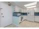 Bright kitchen with white cabinets, blue tile backsplash, and stainless steel appliances at 1 Key Capri # 102E, Treasure Island, FL 33706