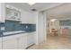 White cabinets, blue tile backsplash, and a built-in dishwasher at 1 Key Capri # 102E, Treasure Island, FL 33706