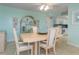 Bright dining room with light wood table and chairs, and view into kitchen at 1 Key Capri # 102E, Treasure Island, FL 33706