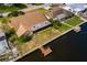 Aerial view of a canal-front house with a private dock and lush landscaping at 165 97Th Ne Ave, St Petersburg, FL 33702
