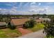 Aerial view of single-story home with brown roof, red brick driveway, and lush green lawn at 165 97Th Ne Ave, St Petersburg, FL 33702