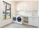 Bright laundry room with washer, dryer, and white cabinets at 1254 Cordova Ne Blvd, St Petersburg, FL 33704