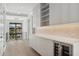 Modern butler's pantry with white cabinets, herringbone backsplash, and wine cooler at 1254 Cordova Ne Blvd, St Petersburg, FL 33704