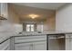 Kitchen features granite countertops, stainless steel dishwasher, and view to living area at 9490 Harbor Greens Way # 205, Seminole, FL 33776