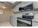 Kitchen features stainless steel range and microwave at 9490 Harbor Greens Way # 205, Seminole, FL 33776