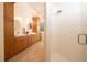 Bright bathroom featuring a double sink vanity with wood cabinets and a walk-in shower with a glass door at 379 Fan Palm Ne Ct # 0, St Petersburg, FL 33703