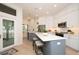 Bright kitchen featuring white cabinetry, stainless steel appliances, quartz countertops, and a gray kitchen island at 379 Fan Palm Ne Ct # 0, St Petersburg, FL 33703