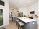 A modern kitchen featuring white cabinets, gray island, stainless steel appliances, and quartz countertops at 379 Fan Palm Ne Ct # 0, St Petersburg, FL 33703