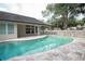 Backyard pool with lush greenery and white fencing, perfect for relaxation and outdoor enjoyment at 379 Fan Palm Ne Ct # 0, St Petersburg, FL 33703