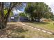 Gray house with blue door and walkway, surrounded by mature trees at 5609 20Th S Ave, Gulfport, FL 33707