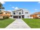 Modern two-story home with a two-car garage and landscaped lawn at 3221 Gulf Blvd, Belleair Beach, FL 33786