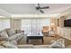 Living room features ample seating, a ceiling fan, and access to a balcony at 36750 Us Highway 19 N # 13202, Palm Harbor, FL 34684