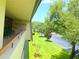 Balcony view showcasing manicured lawn, trees, and a parking lot at 36750 Us Highway 19 N # 21-302, Palm Harbor, FL 34684