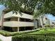 Exterior of building with landscaping and walkway at 36750 Us Highway 19 N # 21-302, Palm Harbor, FL 34684