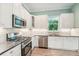 Modern kitchen with stainless appliances, white cabinets, granite counters and a window with natural light at 131 Pennsylvania Ave, Palm Harbor, FL 34683
