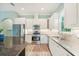 Modern kitchen with stainless appliances, white cabinets, granite counters and an island at 131 Pennsylvania Ave, Palm Harbor, FL 34683