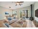 Bright living room features a ceiling fan, fireplace and sliding glass doors to the outside patio at 131 Pennsylvania Ave, Palm Harbor, FL 34683