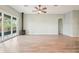 Open-concept living room with wood-look tile flooring, fireplace, ceiling fan and sliding glass doors at 131 Pennsylvania Ave, Palm Harbor, FL 34683