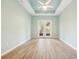 The main bedroom has tray ceilings, French doors and beautiful tile flooring at 131 Pennsylvania Ave, Palm Harbor, FL 34683