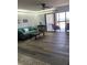 Living room with teal sofa, wood-look floors, and balcony access at 830 S Gulfview Blvd # 601, Clearwater Beach, FL 33767