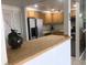 Kitchen with light wood cabinets, stainless steel appliances, and breakfast bar at 830 S Gulfview Blvd # 601, Clearwater Beach, FL 33767