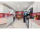 Galley style kitchen with white cabinets and red accent wall at 4936 Mineola Pl, Palm Harbor, FL 34684