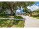 Single-story home with a spacious driveway and mature landscaping at 4936 Mineola Pl, Palm Harbor, FL 34684