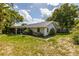 Home's backyard view, showing patio and trees at 4936 Mineola Pl, Palm Harbor, FL 34684