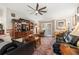 Spacious living room with black leather sofas, a large TV, and ceiling fan at 4936 Mineola Pl, Palm Harbor, FL 34684