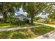 White house with blue shutters, surrounded by lush greenery at 4936 Mineola Pl, Palm Harbor, FL 34684