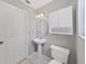 Clean bathroom with pedestal sink, toilet, and white cabinets at 577 Vista Trail Ct, Palm Harbor, FL 34683