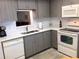 Modern kitchen with gray cabinets and white appliances at 1375 Doolittle Ln # 201, Dunedin, FL 34698