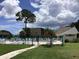 Community pool with lush landscaping and patio furniture at 1375 Doolittle Ln # 201, Dunedin, FL 34698