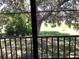 View from a screened-in patio showing a large tree and grassy yard at 1375 Doolittle Ln # 201, Dunedin, FL 34698