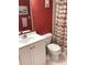 Bright bathroom with white vanity and red walls at 1375 Doolittle Ln # 201, Dunedin, FL 34698