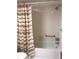 Clean bathroom with shower/tub combo and patterned shower curtain at 1375 Doolittle Ln # 201, Dunedin, FL 34698