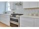 Modern kitchen with stainless steel range and hood, and white countertops and cabinets at 316 11Th N Ave, St Petersburg, FL 33701