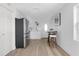 Bright kitchen features white cabinets, stainless steel appliances, modern backsplash, dining table and hardwood floor at 316 11Th N Ave, St Petersburg, FL 33701