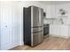 This bright kitchen is complemented by stainless steel appliances, white cabinets, modern backsplash, and hardwood floor at 316 11Th N Ave, St Petersburg, FL 33701