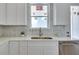 Bright kitchen space with white cabinets, a stainless steel sink, and quartz countertops at 316 11Th N Ave, St Petersburg, FL 33701
