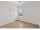 A clean and bright bedroom with hardwood floors, a window view, and a white door at 4234 4Th S St, St Petersburg, FL 33705