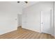 Clean bedroom with wood-look flooring, white walls, and a view into another room at 4234 4Th S St, St Petersburg, FL 33705