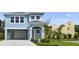 Charming two-story blue home featuring a covered carport, freshly manicured lawn, and modern architectural details at 4234 4Th S St, St Petersburg, FL 33705