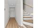Well-lit hallway showcasing hardwood floors, a staircase with wooden handrail, and fresh white paint at 4234 4Th S St, St Petersburg, FL 33705