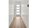Bright hallway features hardwood flooring, white trim, a contemporary white door with window, and a staircase at 4234 4Th S St, St Petersburg, FL 33705