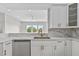Modern kitchen featuring a stainless dishwasher, quartz countertops, and gold hardware fixtures at 4234 4Th S St, St Petersburg, FL 33705